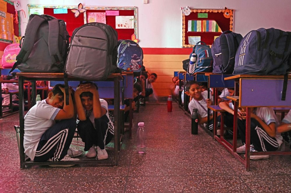 As border tensions surge, students take part in an emergency mock drill as part of the nationwide civil defence mock drill at a school in New Delhi today. — AFP pic