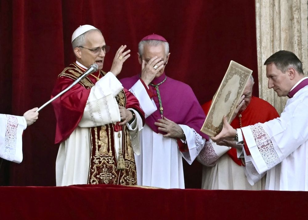 Newly elected Pope Leo XIV, Robert Prevost (left) addresses the crowd on the main central loggia balcony of the St Peter's Basilica for the first time, after the cardinals ended the conclave, in The Vatican, on May 8, 2025. A moderate who was close to Pope Francis and spent years as a missionary in Peru, he becomes the Catholic Church's 267th pontiff, taking the papal name Leo XIV. — AFP pic