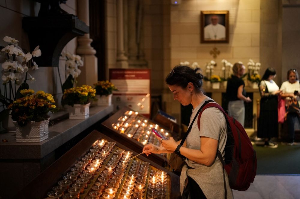 A person lights a candle inside St. Patrick’s Cathedral after the news that Cardinal Robert Prevost of the United States was elected the new pope, taking the name Pope Leo XIV, in New York City May 8, 2025. — Reuters pic