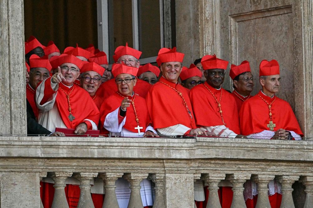 Cardinals react from a balcony of the St Peter's Basilica, as the new pope makes his first appearance after the cardinals ended the conclave, in The Vatican, on May 8, 2025. — AFP pic