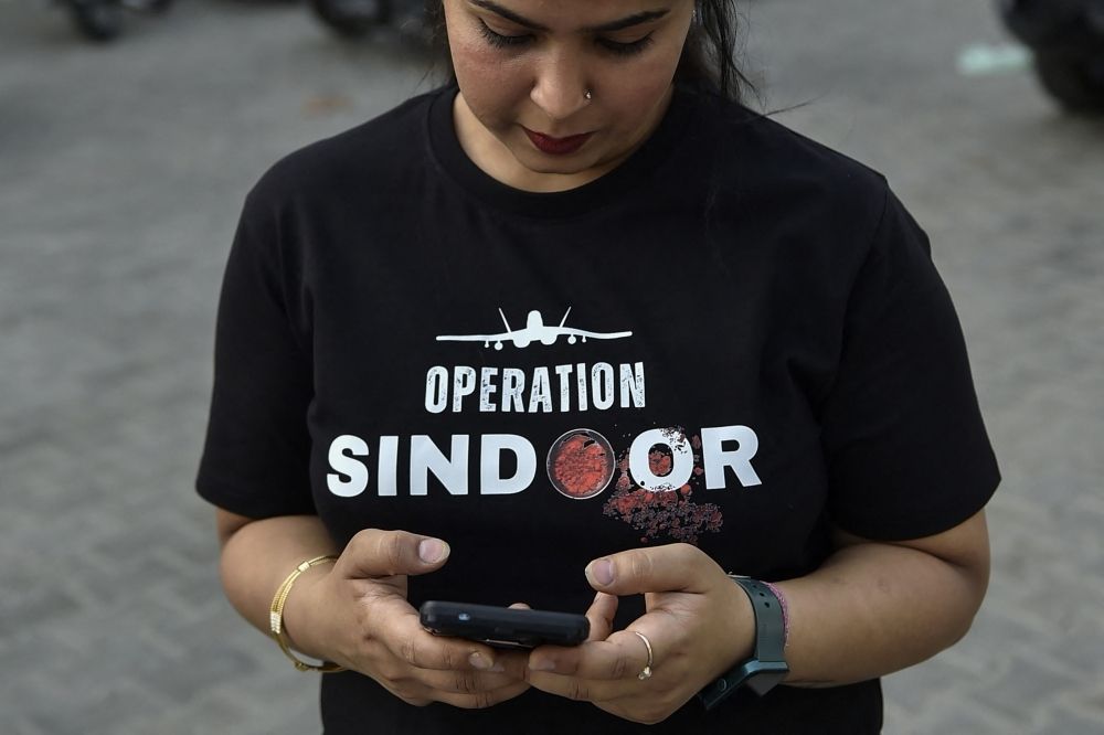 Indian businesses cash in on jingoism with pro-military Operation Sindoor merch after deadly Kashmir attack A woman wearing a T-shirt featuring 'OPERATION SINDOOR' checks her mobile phone near a market area in Ludhiana on May 17, 2025. — AFP pic