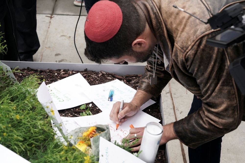 A man writes a message at the Capital Jewish Museum, near the site where two Israeli embassy staff were shot dead, in Washington, D.C. May 22, 2025. — Reuters pic