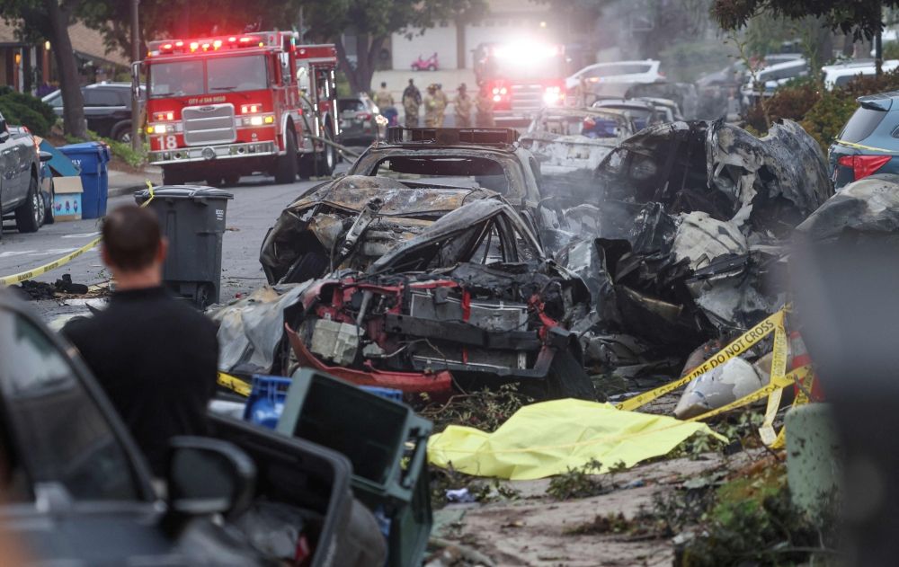Investigators look through the site where a small plane crashed on a San Diego, California, residential street on May 22, 2025. The crash left a ‘gigantic debris field’ and damaged some 15 homes and parked cars, ABC News quoted the San Diego assistant fire chief as saying. — AFP pic