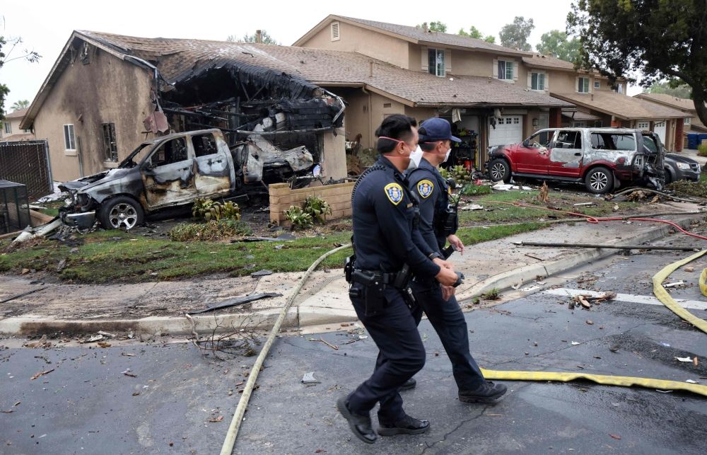 Police officers search the site where a small plane crashed on a San Diego, California, residential street on May 22, 2025. — AFP pic