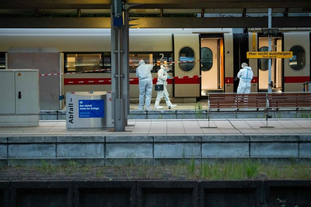 Forensic police officers investigate on the railway platform at Hamburg's main train station where at least 18 people have been injured in a knife attack on May 23, 2025. — AFP pic