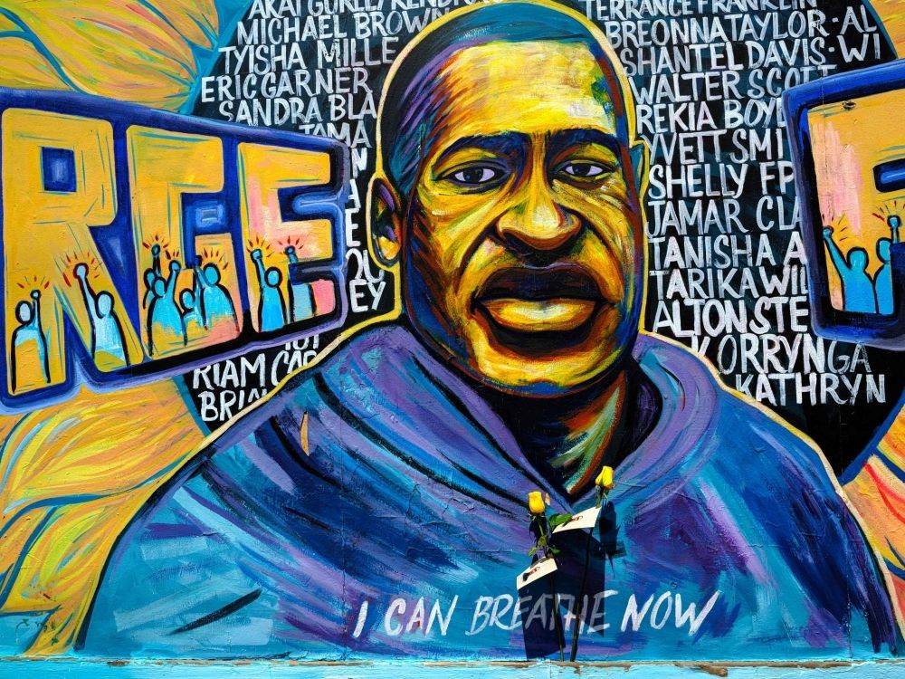 Five years after George Floyd’s killed by cops, Americans face rollback of racial justice reforms under Trump Two yellow roses are pinned to a mural of George Floyd bearing the words