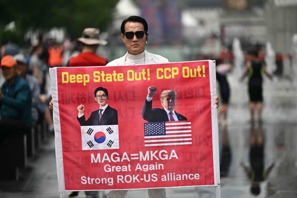A supporter of South Korean presidential candidate Kim Moon-soo of the People Power Party hold a placard as he attends a political rally ahead of the upcoming June 3 presidential election. — AFP pic