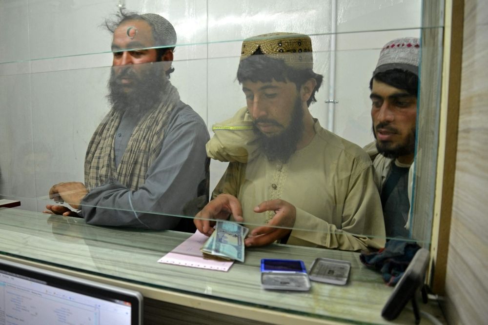 Aidiladha is coming, but Afghan civil servants still waiting on delayed salary while debts mount A Taliban government employee (centre) receives his salary at the New Kabul Bank in Kandahar on June 2, 2025. — AFP pic
