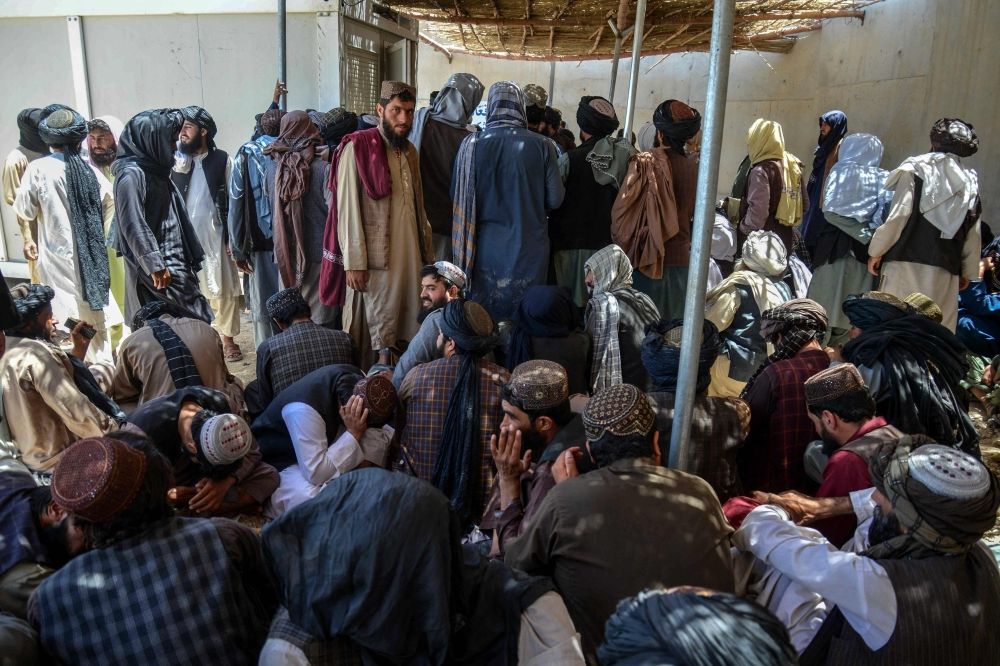 Taliban government employees wait to receive their salaries as they gather outside the New Kabul Bank in Kandahar on June 2, 2025. — AFP pic