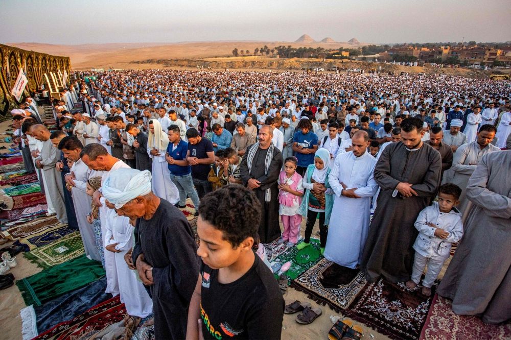 Muslim worshippers perform the early morning prayers for Eid al-Adha, the feast of sacrifice, near the ancient Egyptian Abusir pyramids necropolis in the village of Abusir in the south of Giza province on June 6, 2025. — AFP pic