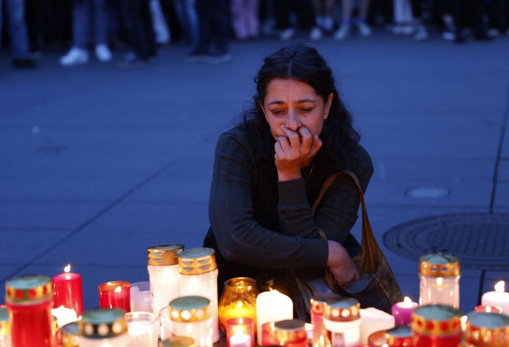 A woman pays her respects at a makeshift memorial site after several people died in a school shooting, on June 10, 2025 in Graz, southeastern Austria. Austrian Chancellor Christian Stocker on Tuesday declared three days of national mourning after a school shooting in the southeastern city of Graz reportedly by a former student left nine people dead and several seriously injured. — AFP pic