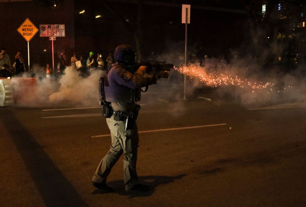 A member of law enforcement fires non-lethal munitions during a rally. — Reuters pic