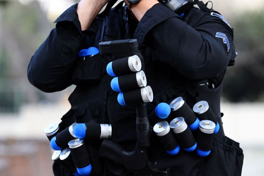 A law enforcement officer carries sponge rounds. — Reuters pic