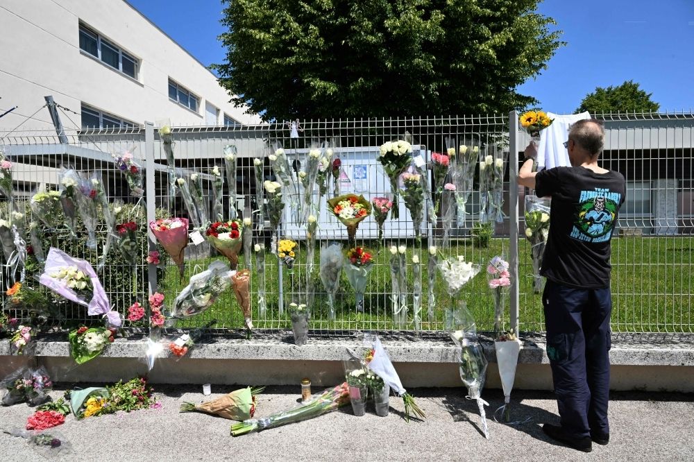 France school stabbing: Teen suspect said he planned to kill ‘any monitor’ after reprimand over kiss A man hangs flowers on the fence of Francoise Dolto middle school in Nogent yesterday. — AFP pic