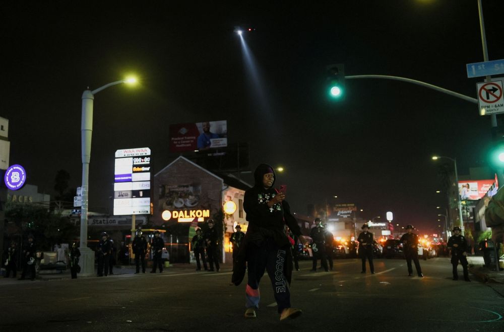 A local tries to get home, as law enforcement officers stand guard, on the day people march as part of the ongoing protests against Immigration and Customs Enforcement (ICE), in Los Angeles, California June 11, 2025. — Reuters pic