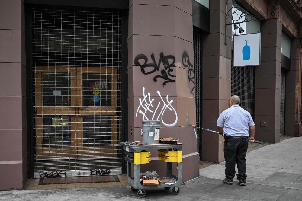 A worker cleans a vandalised storefront following a night of protests in response to federal immigration operations in Los Angeles June 9, 2025. — AFP pic