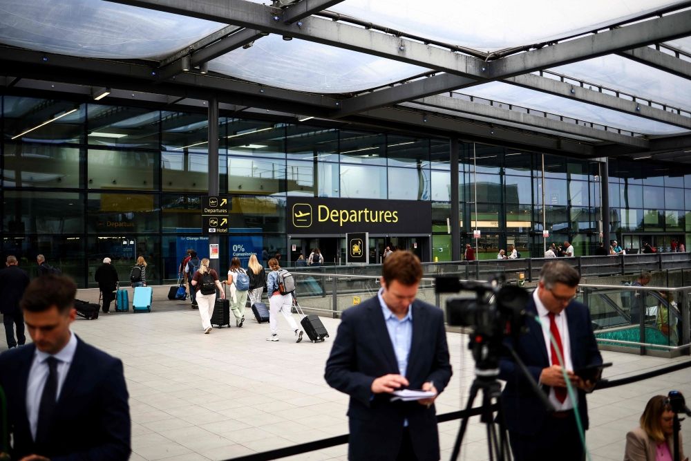 Members of the press gather outside the North terminal upper forecourt in front of the departure entrance at Gatwick Airport, south of London, in June 12, 2025 after a London-bound passenger jet with 242 people aboard crashed shortly after takeoff from India's Ahmedabad airport. — AFP pic