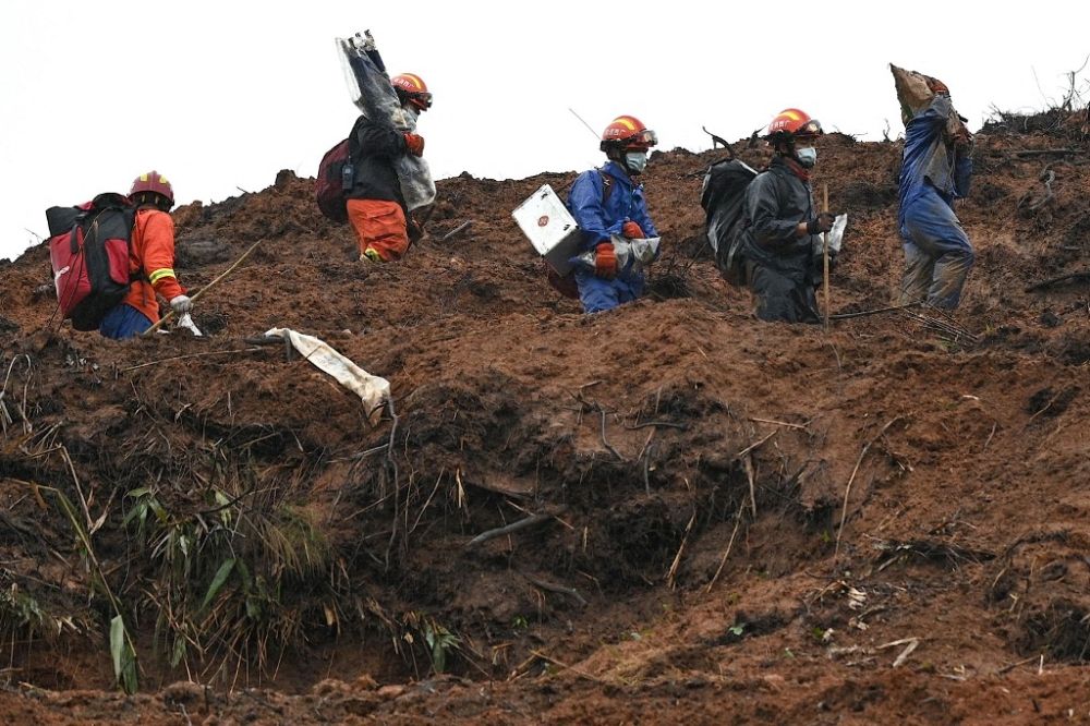 This file photo taken on March 24, 2022 shows rescue workers combing through the site of where China Eastern flight MU5375 crashed on March 21, near Wuzhou in southwestern China’s Guangxi province. — AFP pic