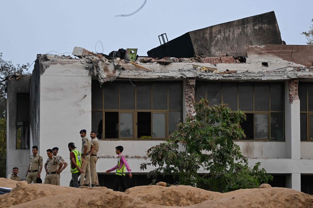 Policemen stand guard at the crash site of Air India flight 171 at a residential area near the airport in Ahmedabad on June 14, 2025, after the Boeing 787-8 aircraft crashed shortly after taking off on June 12. — AFP pic