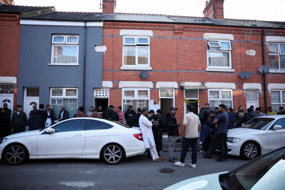 Members of local community stand outside family home of Ramesh Viswashkumar, a British survivor of the London-bound Air India aircraft crash near Ahmedabad Airport in India, in Leicester June 12, 2025. — Reuters pic