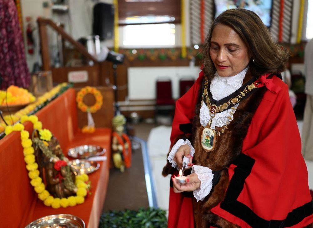 The mayor of Harrow Anjana Patel lits a candle during a vigil at the International Siddhashram Shakti Centre in memory of those who have lost their lives in the Air India crash, in London June 14, 2025. — Reuters pic
