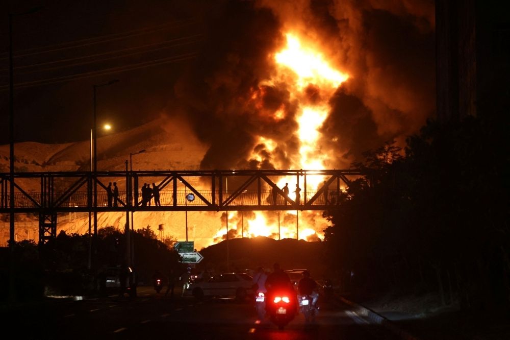 Iran vows ‘heavier’ retaliation after Israeli strikes hit gas field as both sides continue trading fresh missile strikes Fire from an Israeli attack on Sharan Oil depot is seen following the Israeli strikes on Iran, in Tehran, Iran, June 15, 2025. — Majid Asgaripour/WANA (West Asia News Agency) pic via Reuters