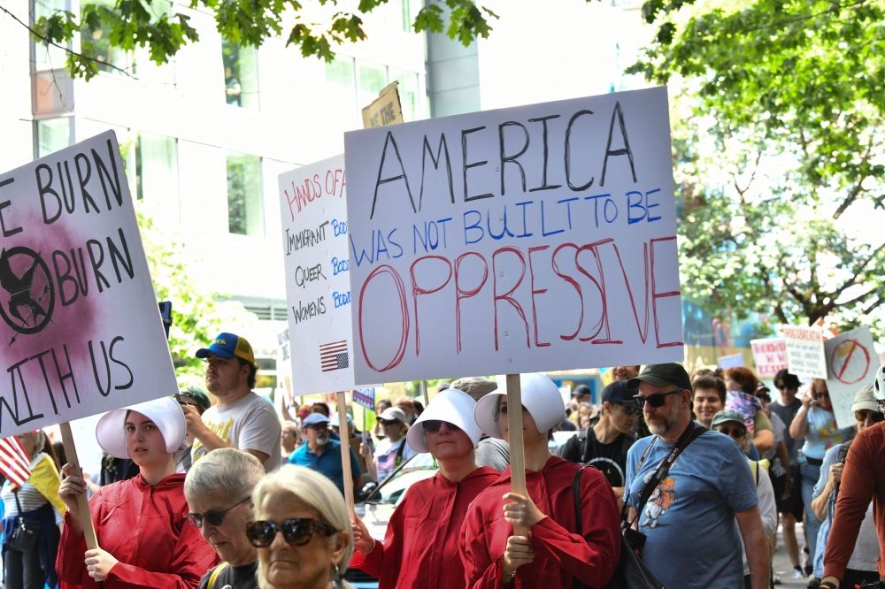 Protesters dressed as characters from ‘The Handmaid's Tale’ hold signs during the ‘No Kings’ national rally in Seattle June 14, 2025. — AFP pic