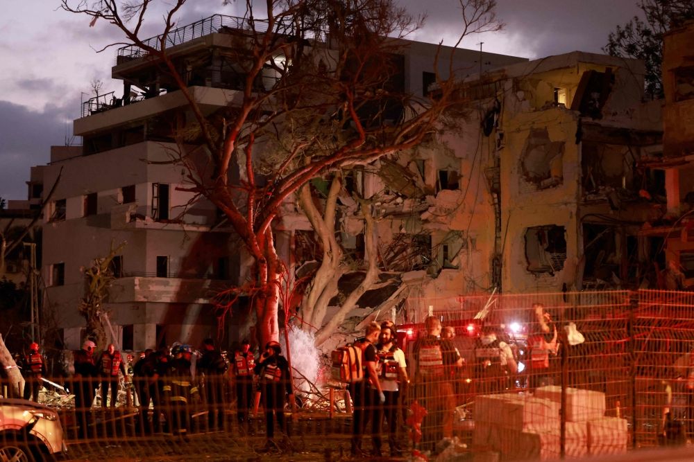 Rescuers work near a damaged building in the Israeli city of Tel Aviv following an Iranian missile attack on June 16, 2025. — AFP pic