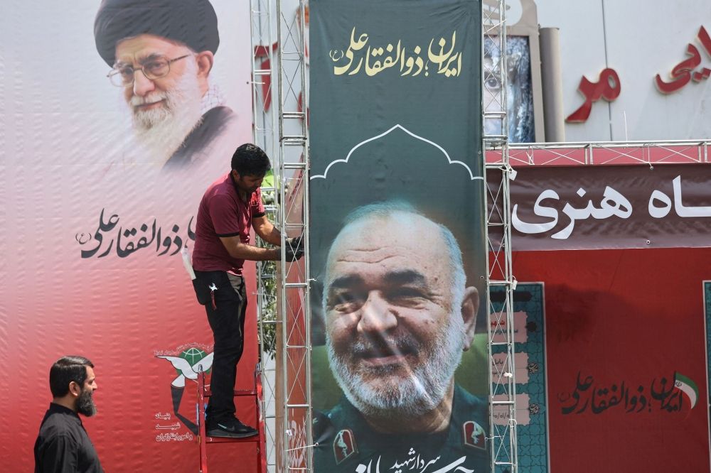A man installs a banner with a picture of late Islamic Revolutionary Guard Corps (IRGC) Commander-in-Chief Major General Hossein Salami, following the Israeli strikes on Iran, in Tehran, June 14, 2025. — Majid Asgaripour/Wana(West Asia News Agency)/Reuters pic