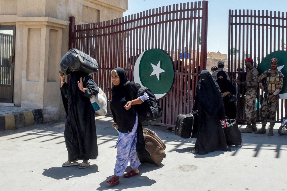 Pakistani pilgrims evacuated from Iran walk across the Pakistan-Iran border at Taftan, in Balochistan province on June 18, 2025, amid the ongoing conflict between Israel and Iran. — AFP pic