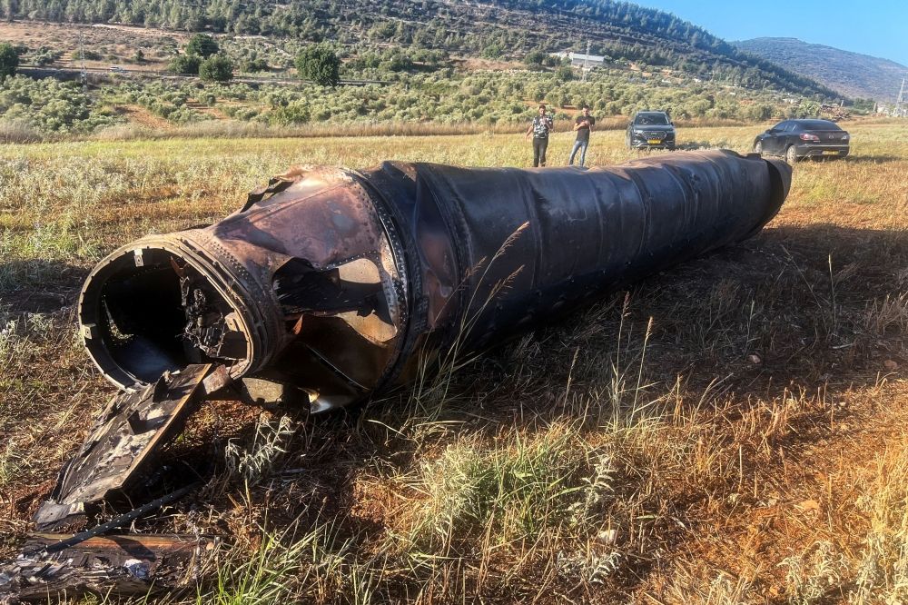Locals look at an apparent remains of a ballistic missile lying on the ground following missile attacks by Iran on Israel, amid the Iran Israel conflict, in northern Israel, June 20, 2025. — Reuters pic