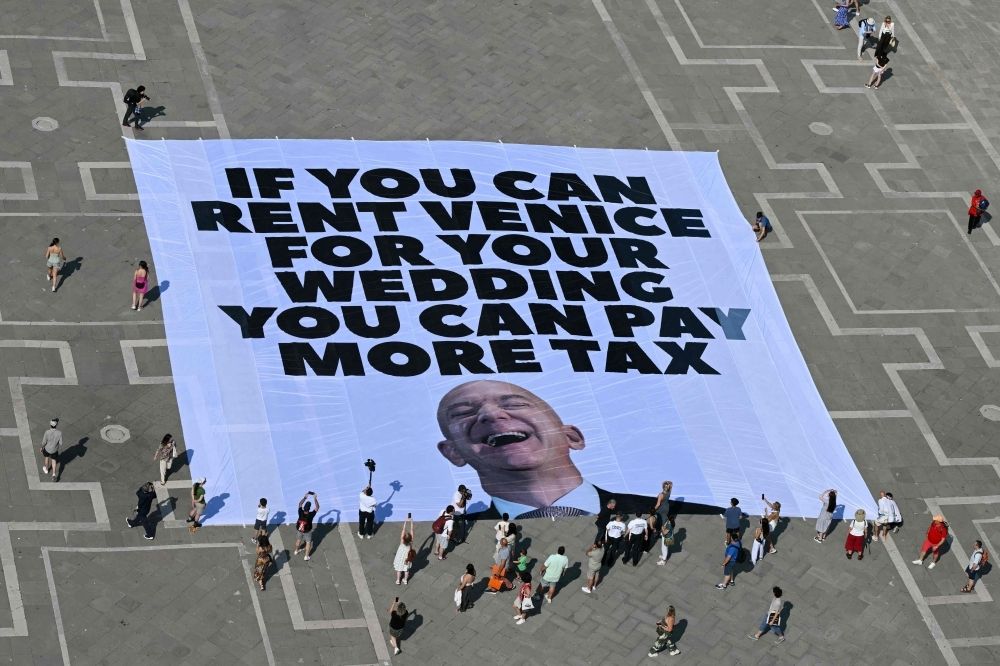 Private jets and public anger as Amazon billionaire Jeff Bezos celebrates wedding in fragile Venice Activists from international environmental group Greenpeace display a giant banner featuring a photo of Jeff Bezos and the message