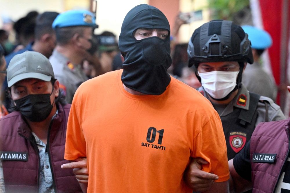 Police officers escort Australian suspect Darcy Francesco Jenson to a press conference at Badung district police station in Badung, on June 26, 2025. — AFP pic