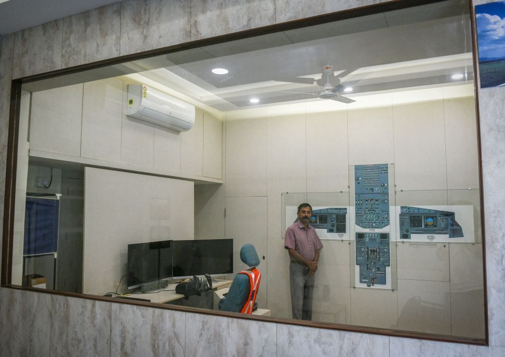 Retired Indian Air Force (IAF) wing commander K. Dinesh poses for pictures next to the layout of a cockpit in the demo room of Cockpit Vista in Bengaluru, India June 23, 2025. — Reuters pic