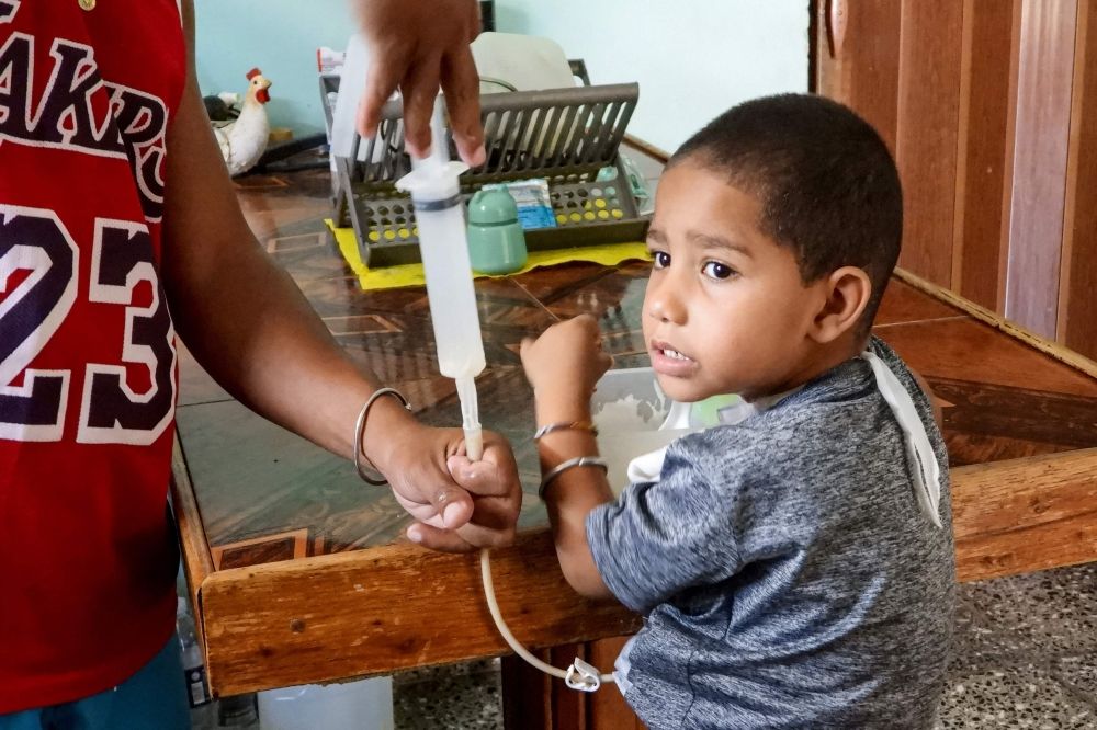 Cuba’s drug crisis: Families scour black market as pharmacies run dry, children’s lives hang in the balance Alberto Romero feeds his son, Luis Angelo, who requires artificial feeding due to a tracheostomy, at their home in the Santa Fe neighbourhood of Havana July 2, 2025. — AFP pic