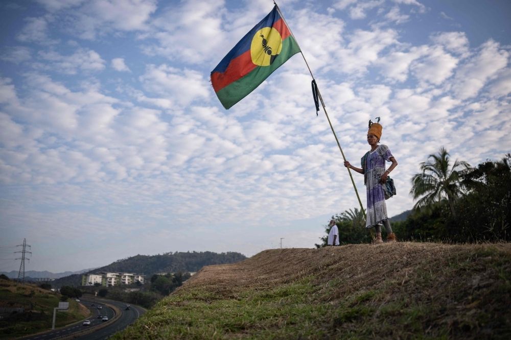 New Caledonia to gain state status and own nationality under French deal after separatist violence A woman with a traditional dress holds a Kanak flag in the Dumbea district of Noumea, in France's Pacific territory of New Caledonia on September 24, 2024. — AFP pic