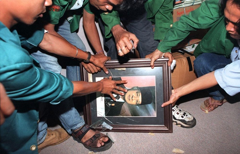 Indonesian students smash a portrait of former president Suharto in one of the offices of the parliamentary complex in Jakarta on May 21, 1998. — AFP pic Indonesian students smash a portrait of former president Suharto in one of the offices of the parliamentary complex in Jakarta on May 21, 1998. — AFP pic