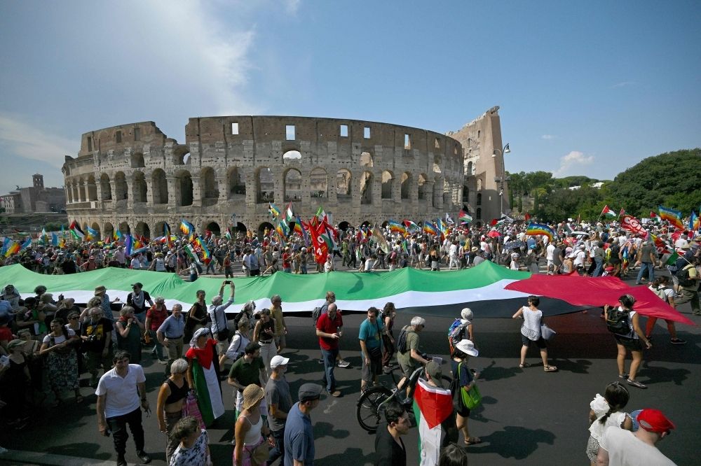 Despite mass rallies, Italy’s fractured left fails to mount real challenge to Meloni’s rising far-right popularity People holding a giant Palestinian flag pass by the Colosseum as they take part in a national demonstration named
