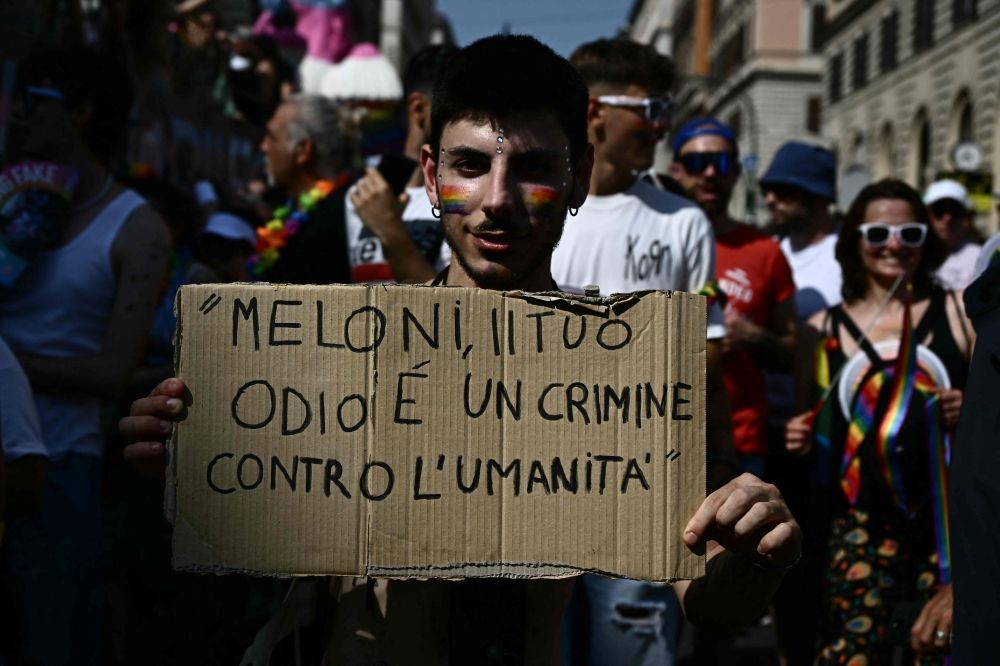 A man poses with a placard reading 'Meloni, your hate is a crime against humanity' during the Pride march in support of LGBTQ rights, in Rome on June 14, 2025. — AFP pic A man poses with a placard reading 'Meloni, your hate is a crime against humanity' during the Pride march in support of LGBTQ rights, in Rome on June 14, 2025. — AFP pic