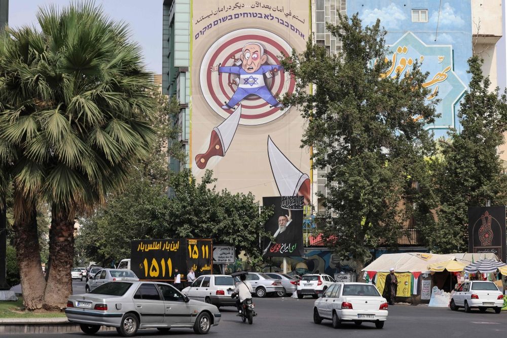 An anti-Israel cartoon mocking Israel's Prime Minister Benjamin Netanyahu is displayed at Palestine Square in central Tehran on July, 13, 2025. — AFP pic An anti-Israel cartoon mocking Israel's Prime Minister Benjamin Netanyahu is displayed at Palestine Square in central Tehran on July, 13, 2025. — AFP pic
