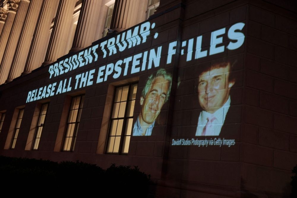 NYT: Epstein was the only guest at Trump’s Mar-a-Lago party with ‘young women’ An image of US President Donald Trump and Jeffrey Epstein, along with the words “President Trump: Release All the Epstein Files”, is projected onto the US Department of Commerce headquarters in Washington, DC, on July 18, 2025. — AFP pic