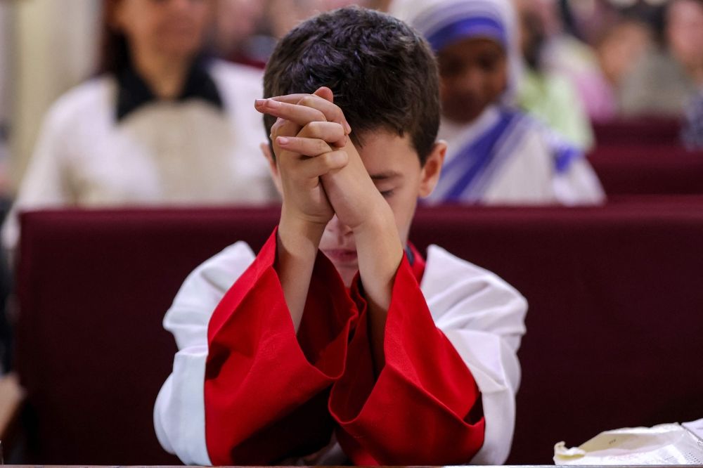 A young altar server holds his hands in prayer during Sunday morning mass at the Roman Catholic Church of the Holy Family in Gaza City on July 20, 2025. — AFP pic A young altar server holds his hands in prayer during Sunday morning mass at the Roman Catholic Church of the Holy Family in Gaza City on July 20, 2025. — AFP pic