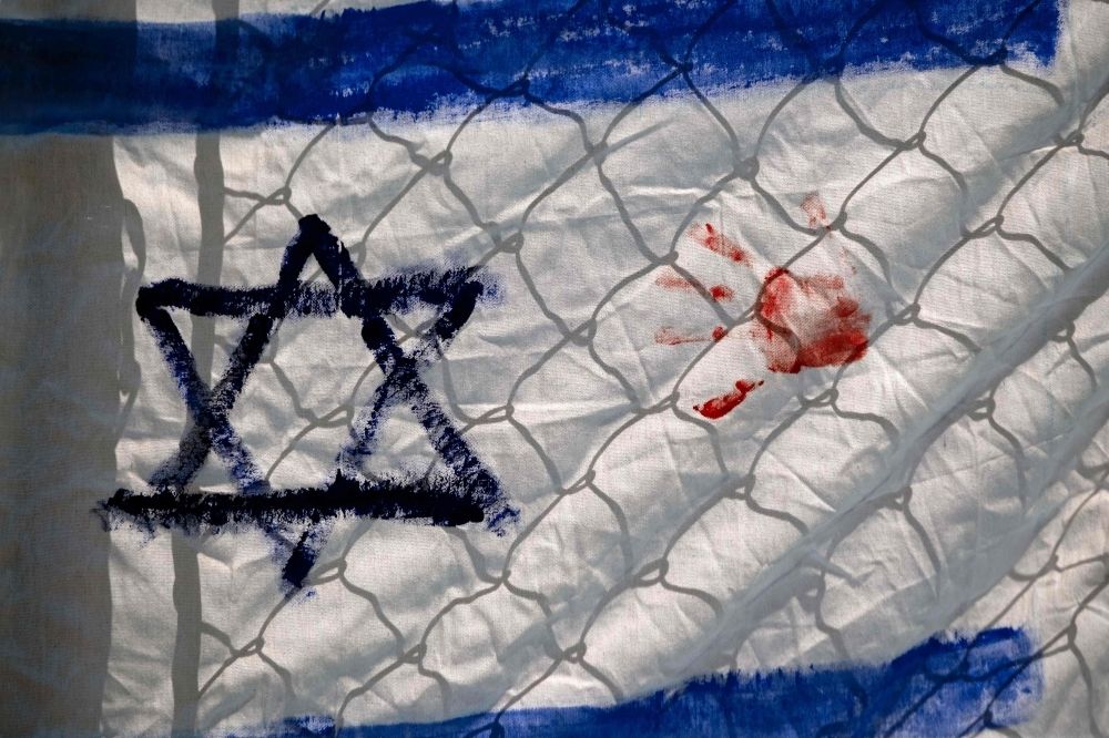 As Gaza famine worsens, Netanyahu’s war against Palestinians finally turns Israelis against each other A makeshift Israel flag with a red hand printed on it is pictured during a pro-Palestinian rally outside Mexico's Foreign Ministry offices against Israel's actions and the ongoing food shortages in the Gaza Strip in Tijuana, Baja California state, Mexico on August 3, 2025. — AFP pic