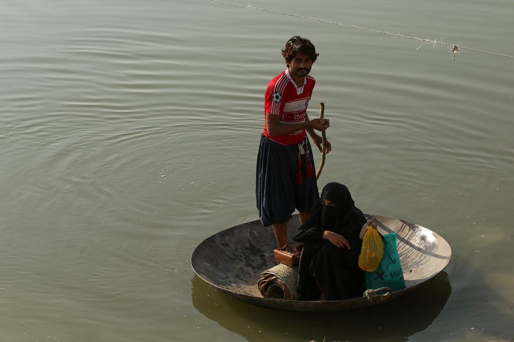 Villagers use a large cooking cauldron and pull a rope to cross floodwaters following heavy rains in Ehsan Pur village, Kot Addu district of Punjab province, on August 21, 2025. — AFP pic Villagers use a large cooking cauldron and pull a rope to cross floodwaters following heavy rains in Ehsan Pur village, Kot Addu district of Punjab province, on August 21, 2025. — AFP pic