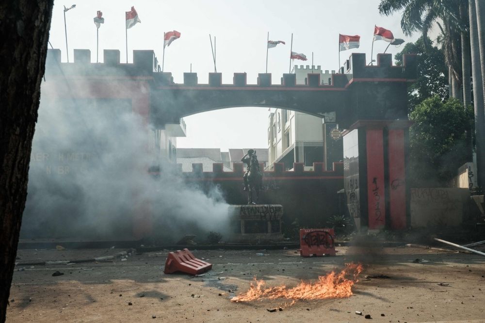Indonesian police fire tear gas at protesters demanding justice for driver run over by tactical vehicle A molotov cocktail burns on the ground amidst a cloud of tear gas in front of the main gate of the headquarters of the Mobile Brigade Corps, or 'Brimob', during clashes with people protesting against the death of a motorcycle taxi driver the night before, in front of the Brimob headquarters in Jakarta on August 29, 2025. — AFP pic
