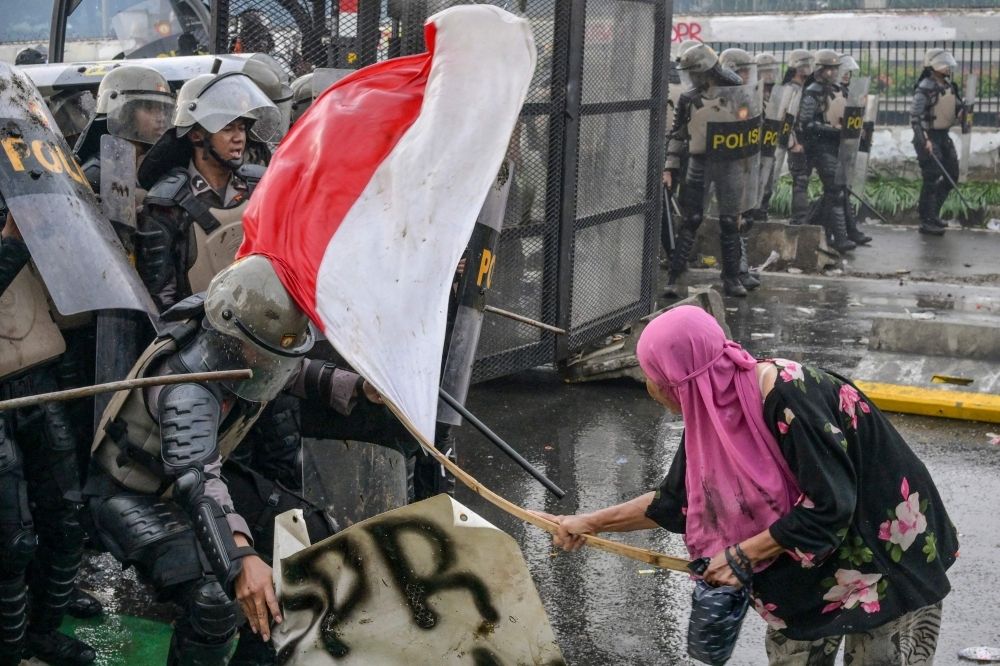 Prabowo faces first big test as Indonesians demand police reform after ride-hailing driver’s death A woman strikes a police officer with a bamboo stick tied to an Indonesian flag as police push back students during a protest outside the parliament building against lawmakers’ demands for higher allowances in Jakarta on August 28, 2025. — AFP pic