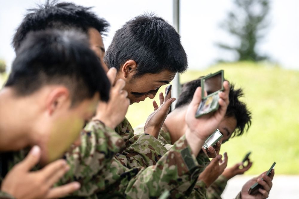 Members of the Japan Ground Self-Defence Force (JGSDF) putting on camouflage face paint during an exercise at JGSDF Camp Naha in Okinawa Prefecture June 9, 2025. — AFP pic Members of the Japan Ground Self-Defence Force (JGSDF) putting on camouflage face paint during an exercise at JGSDF Camp Naha in Okinawa Prefecture June 9, 2025. — AFP pic