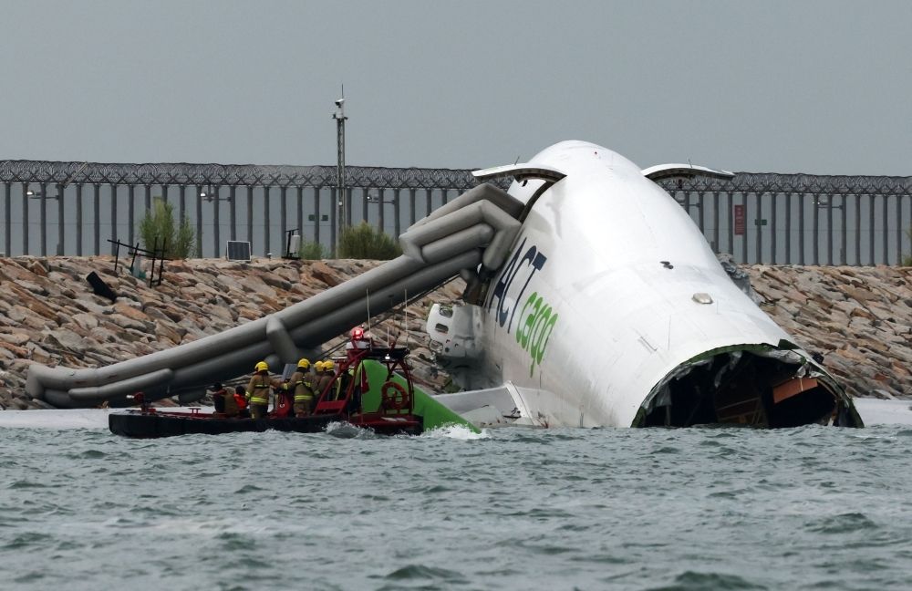 Cargo plane skids off runway into sea at Hong Kong airport, killing two in patrol vehicle, flights unaffected Emergency personnel work near a cargo plane lying partially in the sea after it veered off the runway during landing at Hong Kong International Airport in Hong Kong October 20, 2025. — Reuters pic