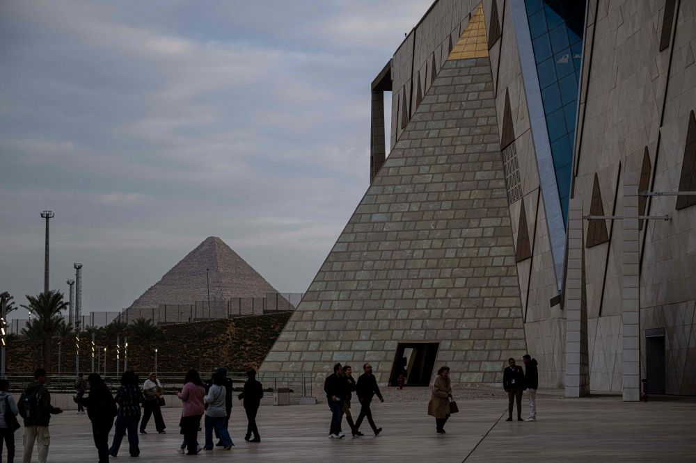 Visitors walk outside the Grand Egyptian Museum in Giza on the southwestern outskirts of the capital Cairo set to open fully on November 1, 2025, after years of delays caused by political instability, economic crises and the global pandemic. — AFP Visitors walk outside the Grand Egyptian Museum in Giza on the southwestern outskirts of the capital Cairo set to open fully on November 1, 2025, after years of delays caused by political instability, economic crises and the global pandemic. — AFP