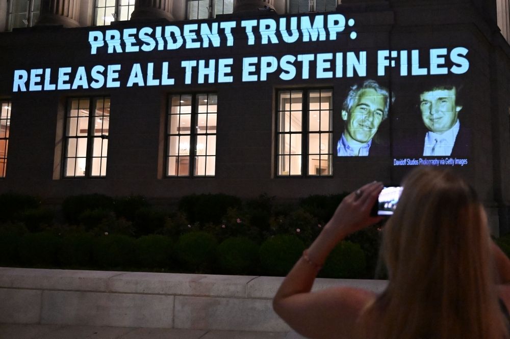 Can Trump outrun Epstein’s shadow? Explosive emails reignite political storm, test Republican unity A person takes a photo as a message calling on President Donald Trump to release all files related to Jeffrey Epstein is projected onto the US Chamber of Commerce building across from the White House in Washington, DC July 18, 2025. — AFP pic